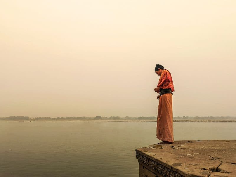 Person reflecting as they look at the lake below.