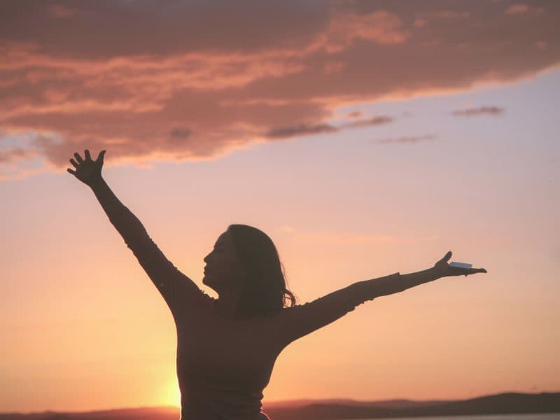 Person holding hands in the air representing feeling light and free.