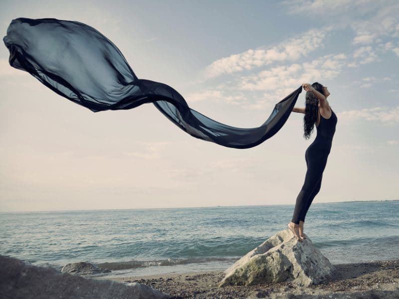 Woman feeling free with long scarf representing time, patience, and compassion.