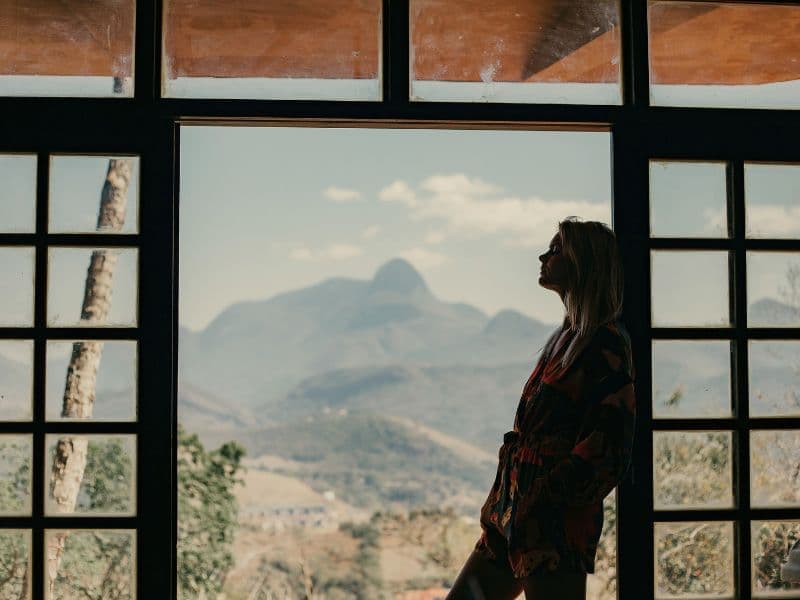 Person leaning on door breathing in crisp air as light seeps in.