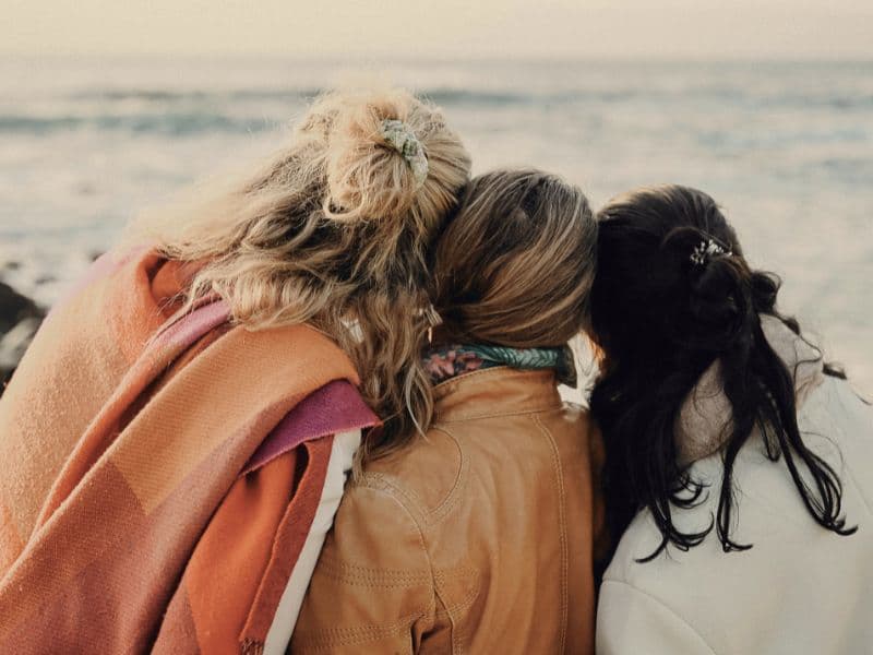 Friends looking out at the calm sea together.