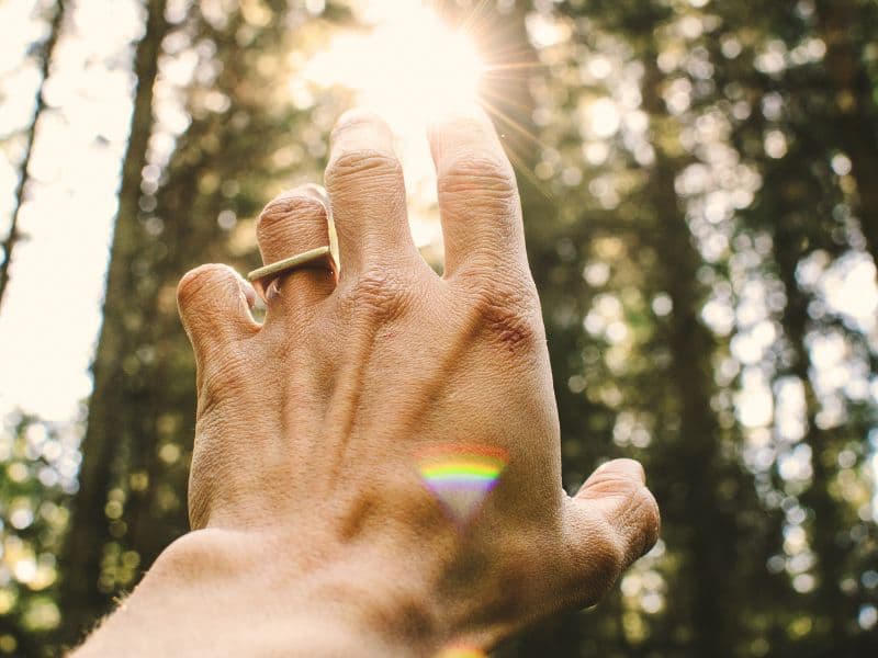 Person reaching for the light symbolizing hope for a more meaningful life through healing.