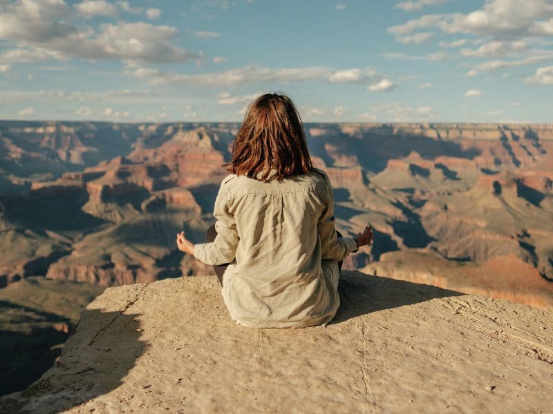 Woman meditating in nature representing the idea that healing is possible and requires patience.