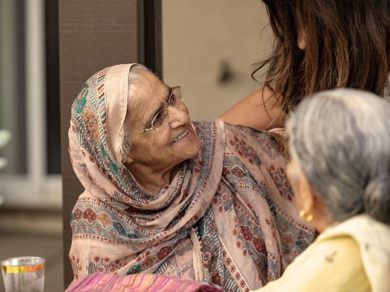 Girl engaging in conversation with grandma representing the idea of open conversations to break generational patterns.