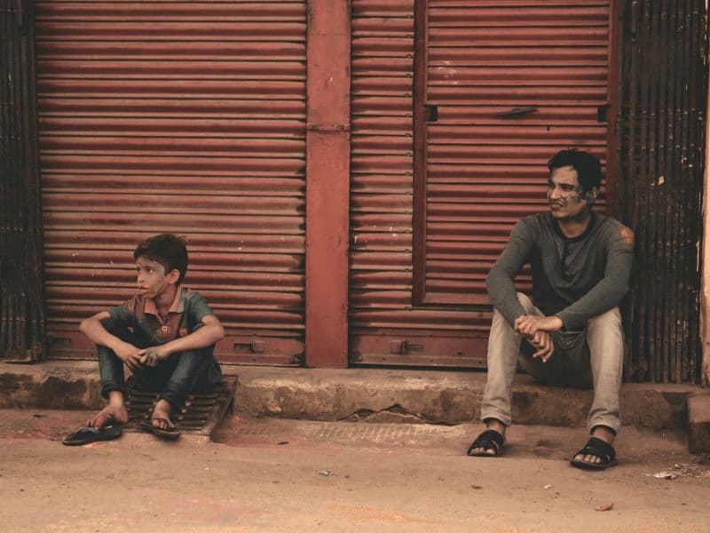 Dad and son sitting separately representing the distance that emotional neglect creates.