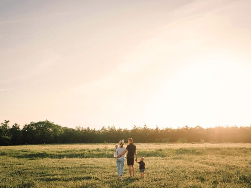 Family sharing a peaceful moment together at sunset, representing healing, emotional safety, and healthier relationships after childhood trauma.