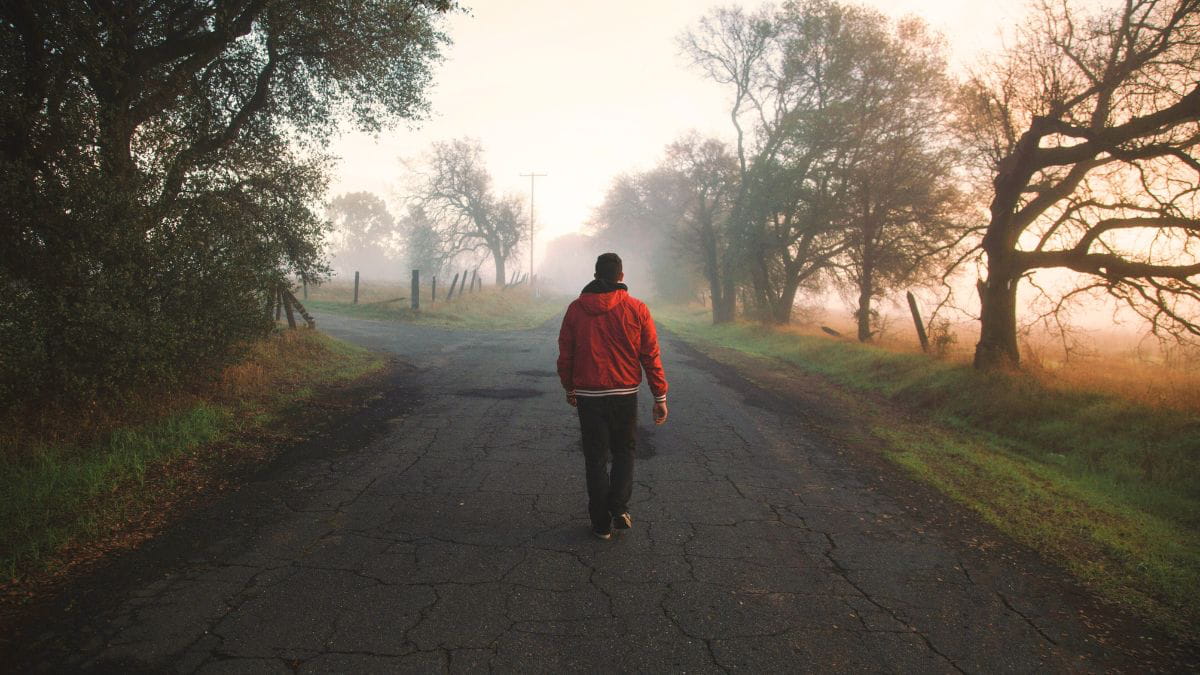 Man walking down an empty, foggy road representing navigating uncertainty in recognizing abuse.