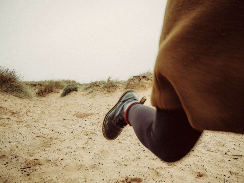 Person's legs that appear to be running away, representing flight as a survival mechanism.