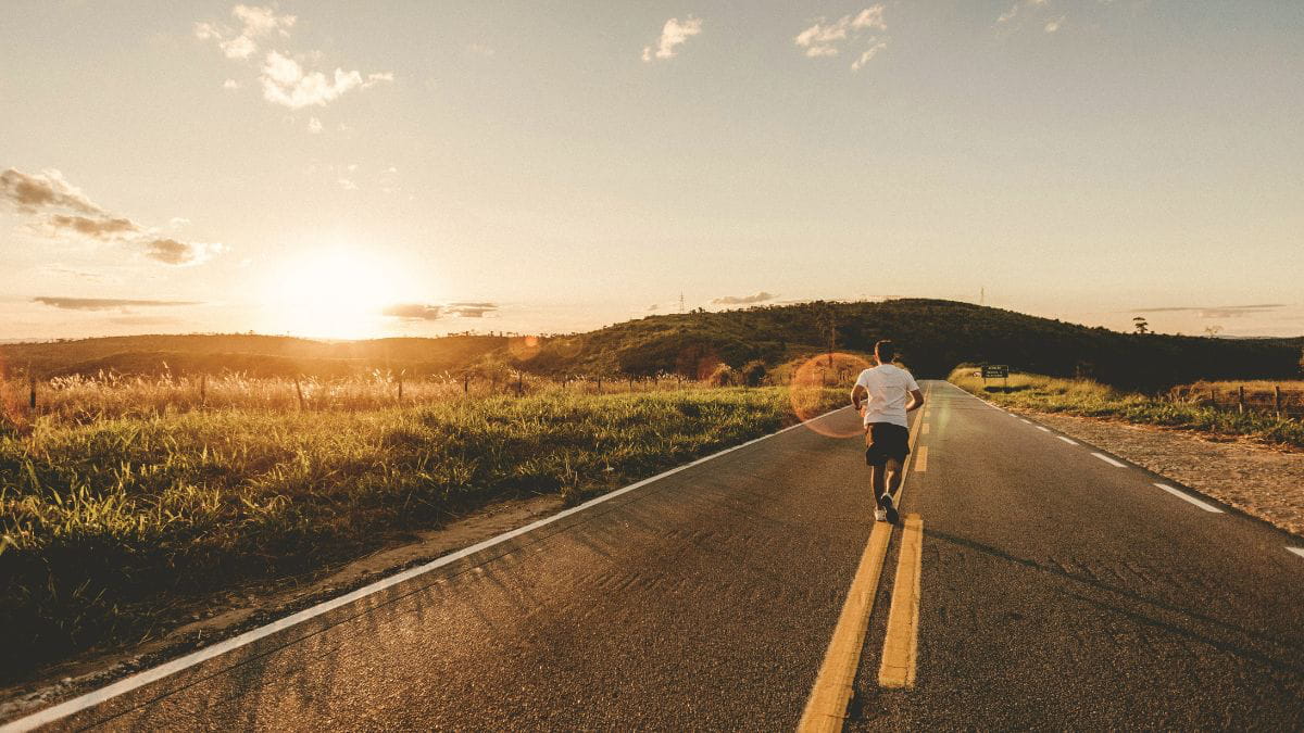 Man running on an empty road at sunset representing the flight trauma response.