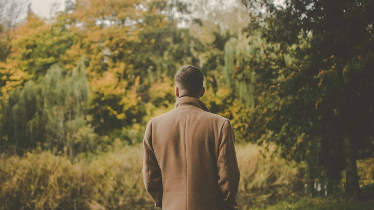 Man standing alone in a forest reflecting on hidden trauma and emotional struggles as a high-functioning adult.