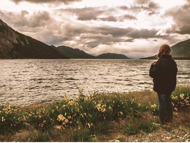 Woman looking over a lake toward the mountains, symbolizing hope and healing after recognizing abuse.