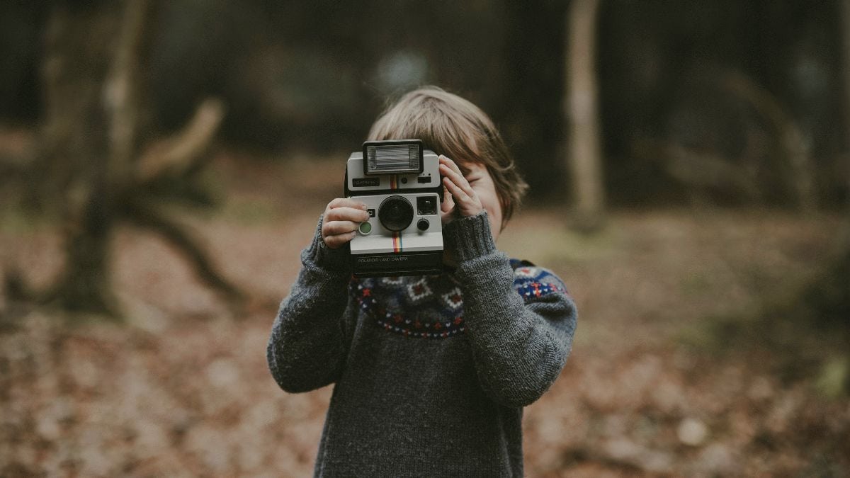 Child taking a photo in nature, symbolizing grieving a childhood you never had while healing from childhood trauma.